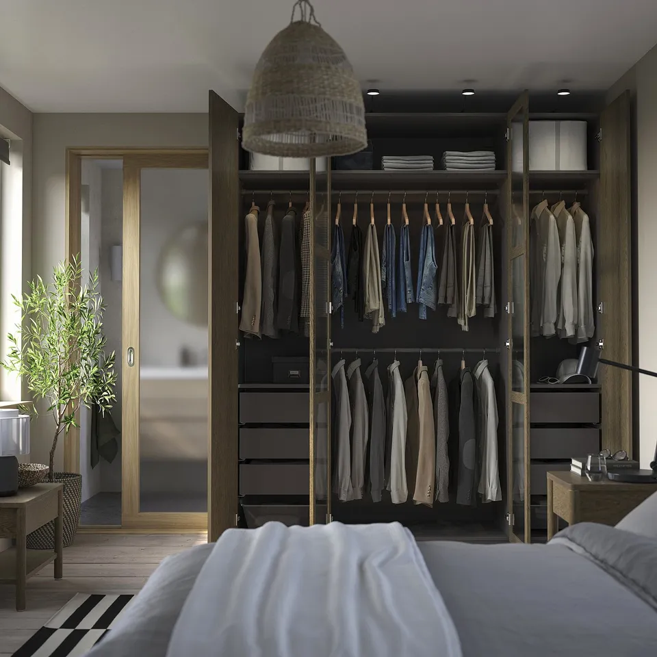 Wardrobe with clothes, bed, light, balcony door, plant.