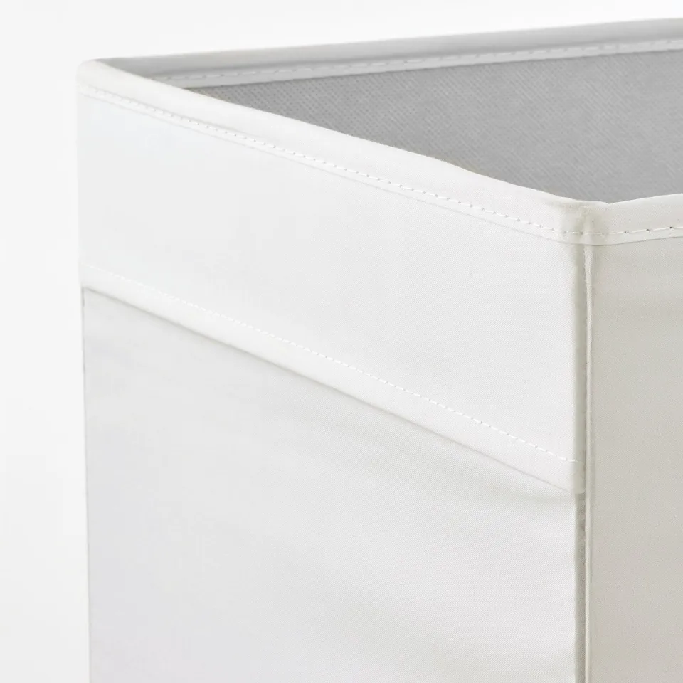 Depicts a corner of a white fabric storage box. It shows neat stitching and sturdy construction, emphasising its quality and organisation potential.