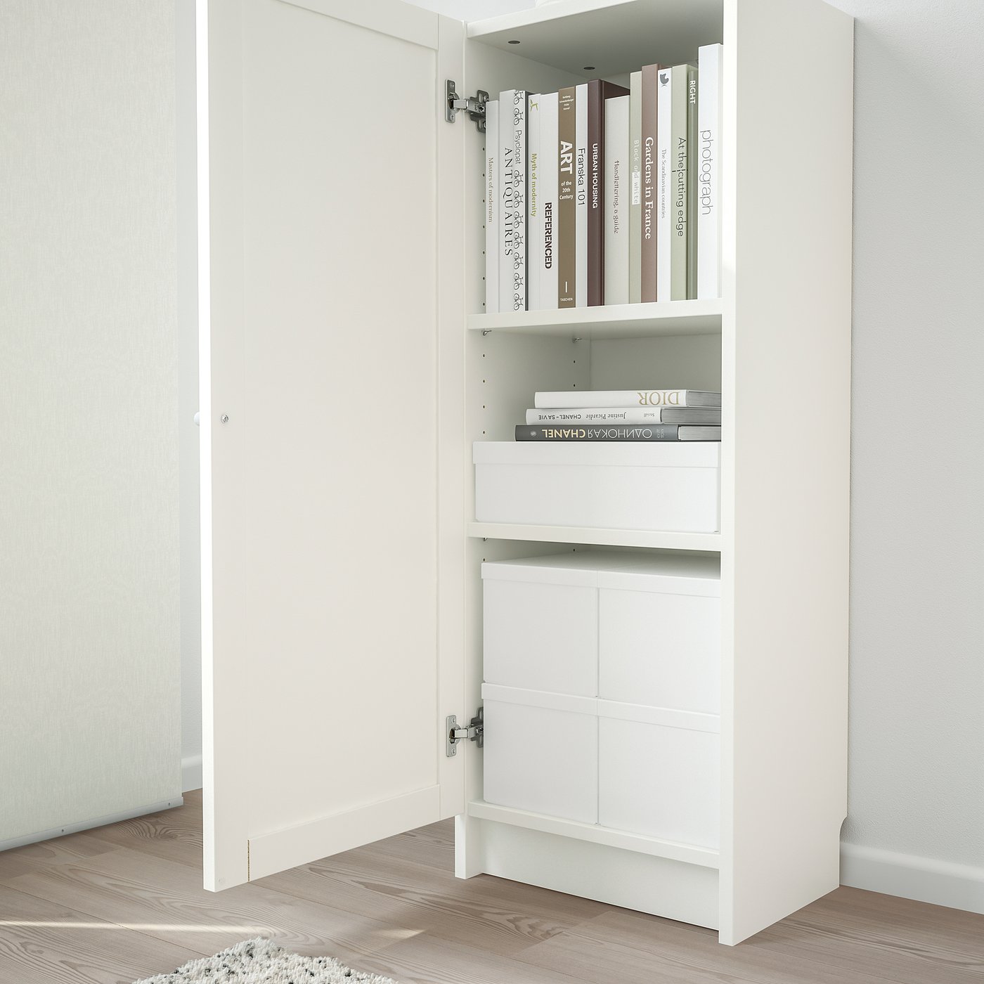 White bookshelf with closed door, housing books and boxes in organised manner.