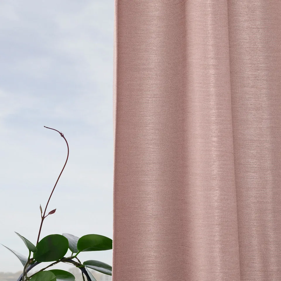 Sheer pink VILBORG curtains, blocking light, hanging near green plant, creating privacy.