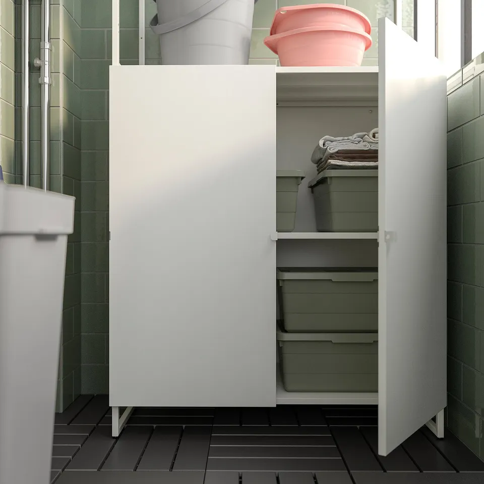 White storage cabinet, with green plastic bins, closed door, in bathroom, sturdy steel.