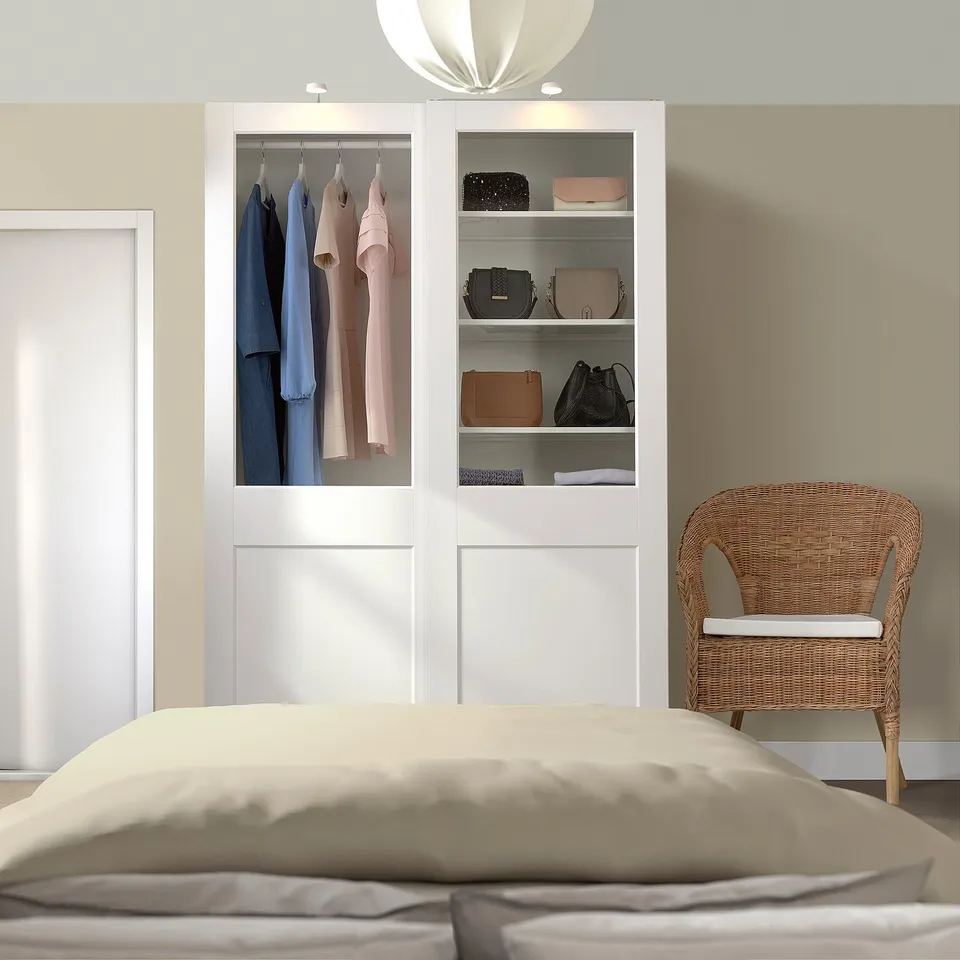 Modern bedroom with PAX wardrobe, glass doors, clothes, chair, bed.