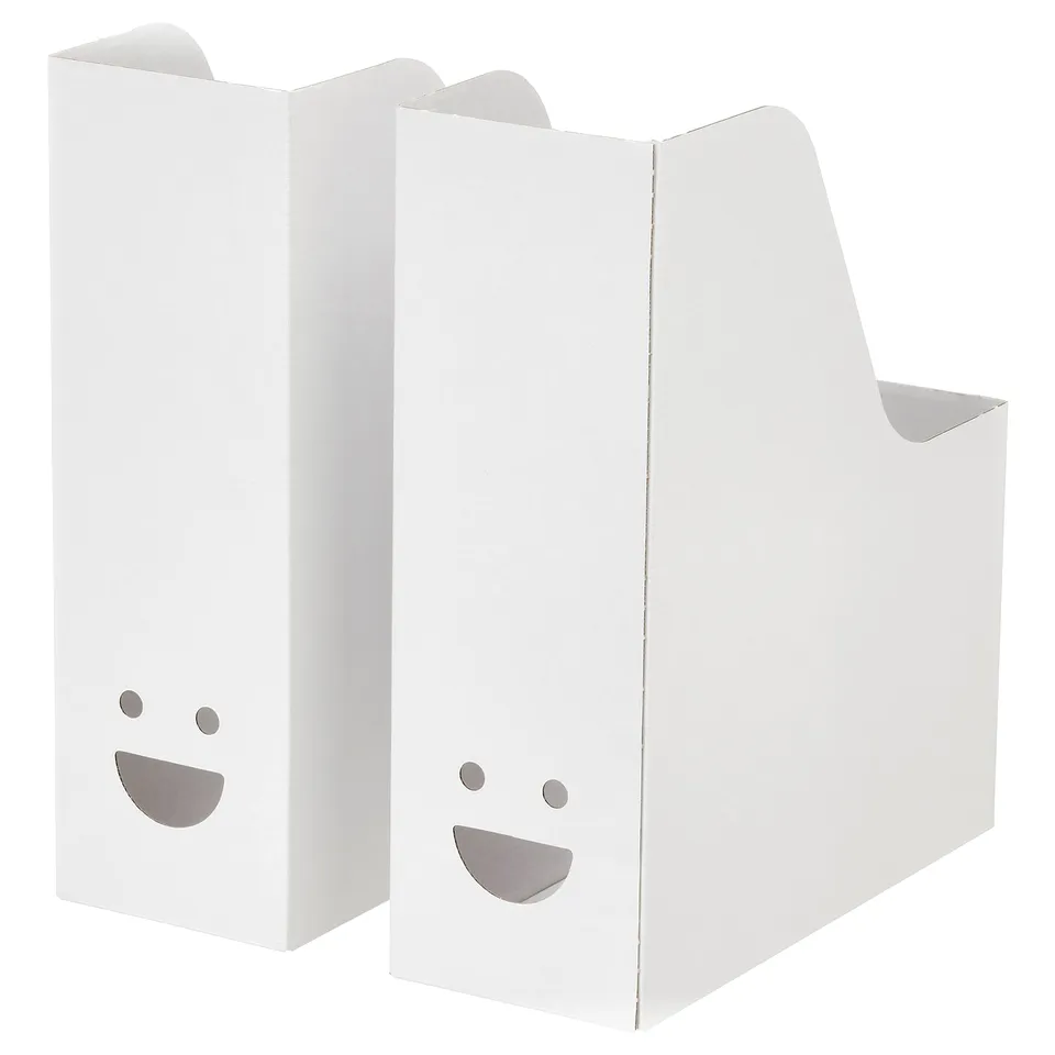 Two white TJABBA magazine files, upright with smiling faces cut out.