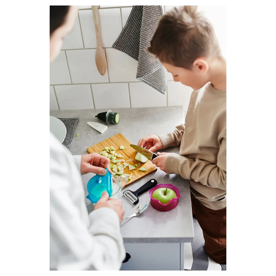 Two people chopping veggies in modern kitchen.