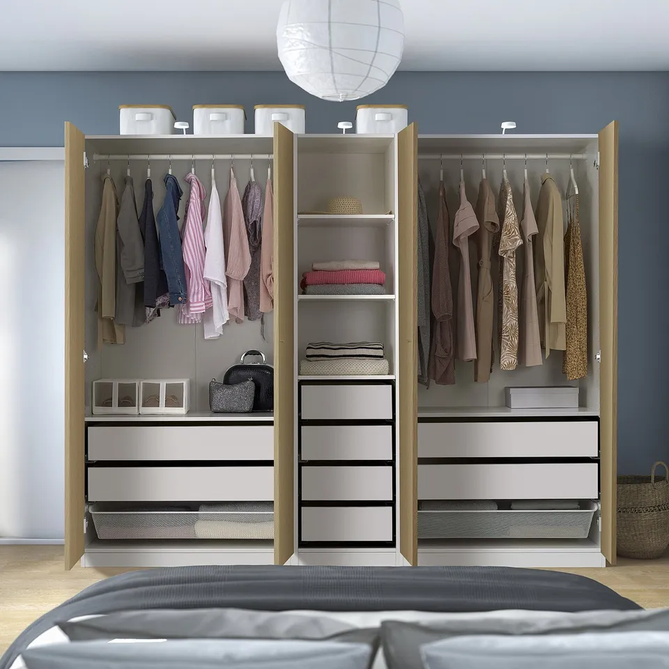 Open wardrobe displaying organised clothes, shelves, and drawers inside a PAX unit.