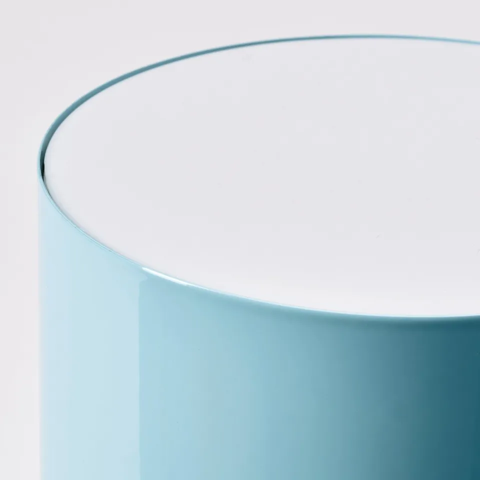 Curved light blue table lamp with sleek design.