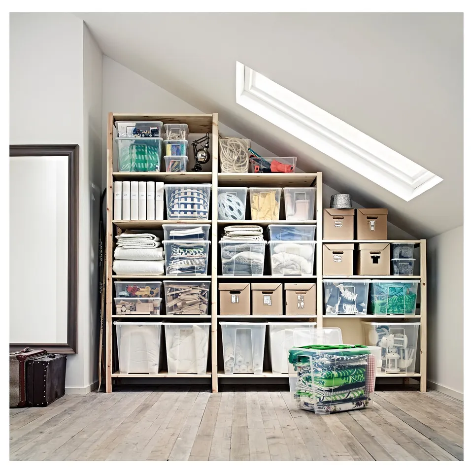 IVAR shelves with plastic bins, boxes, and blankets in attic with skylight.