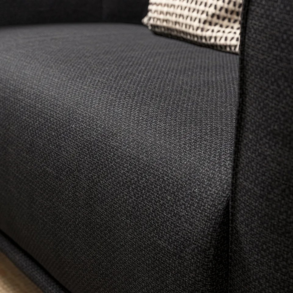 Close-up of VISKAFORS armchair in dark grey fabric, showing textured weave and plush seat.