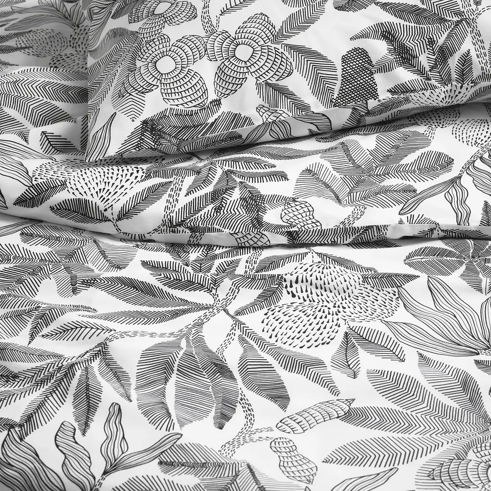 Black and white patterned bed sheet with intricate, embroidery-like florals and leaves, showcasing high-quality, smooth fabric.
