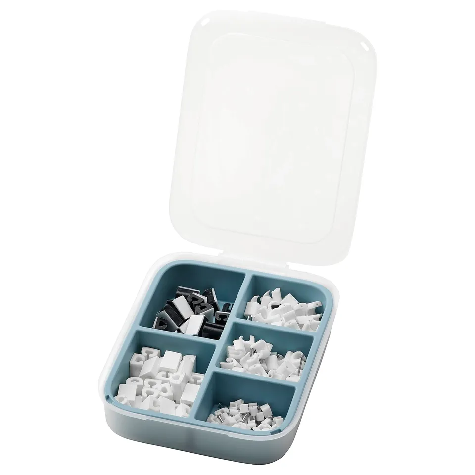 Open blue plastic toolbox with clear lid. Holds white and black plastic fasteners in four compartments.