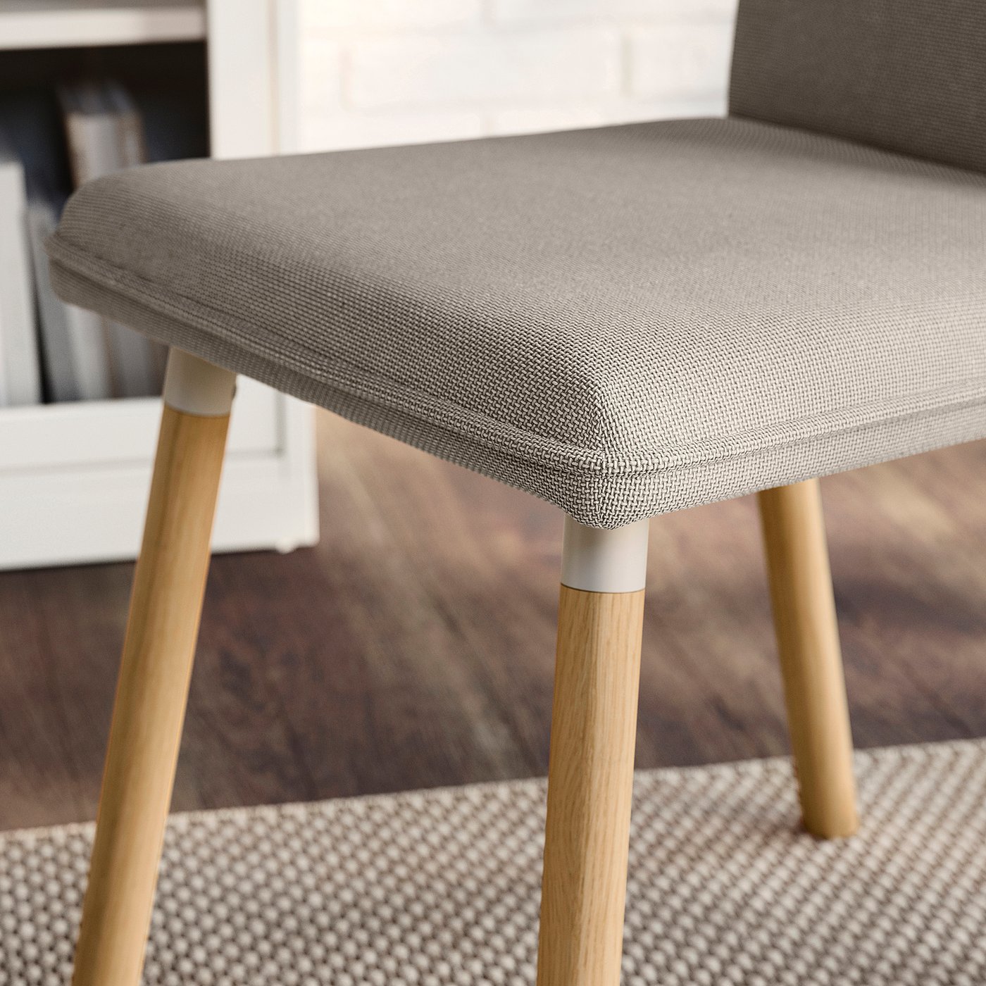 Modern upholstered chair with wooden legs, grey fabric cover, and sleek design.