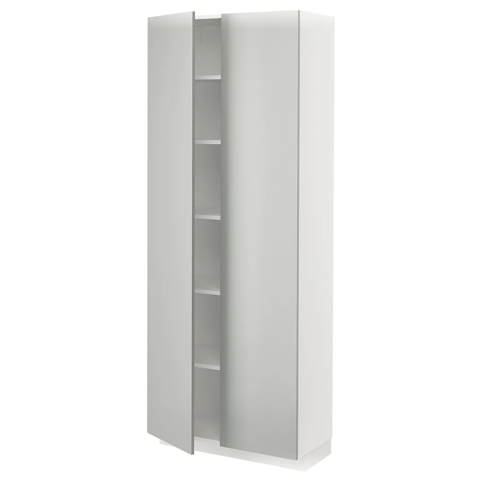 A white METOD kitchen cabinet with light grey havstorp doors, featuring a modern, clean design with multiple shelves inside.