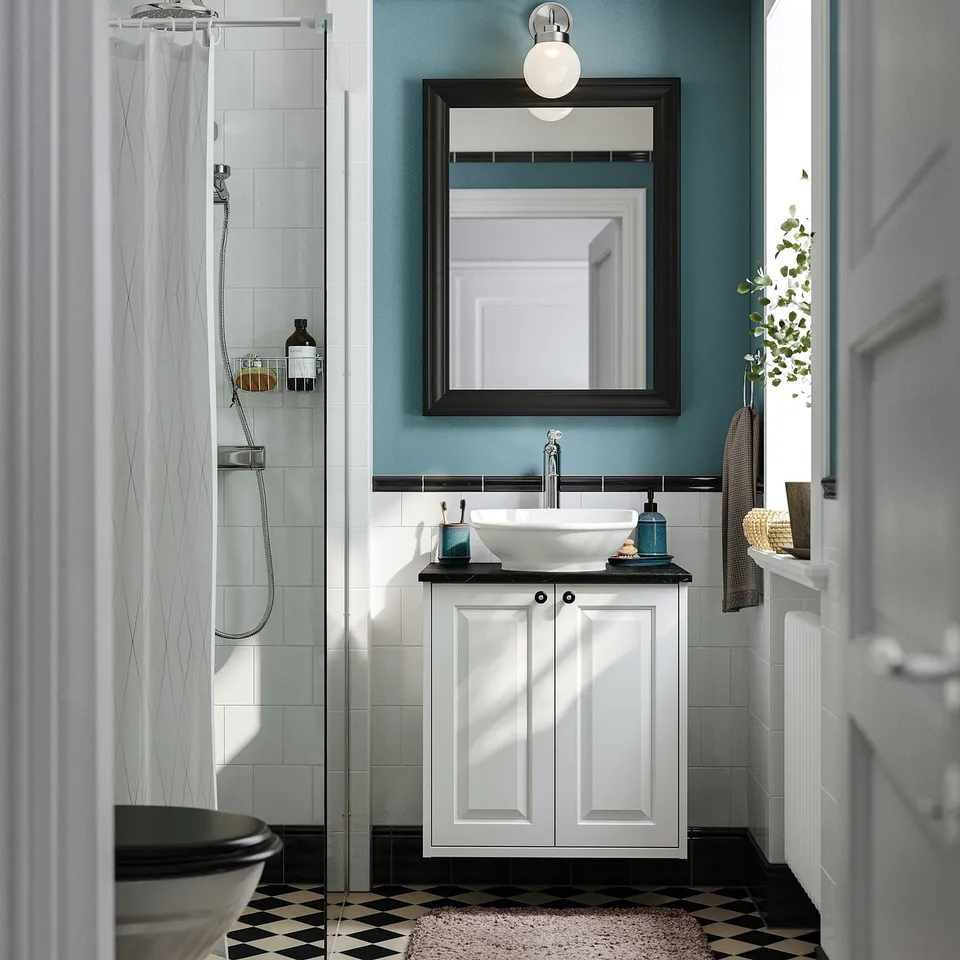Bathroom with TÄNNFORSEN vanity, round basin, black-and-white floor, blue-green walls, and glass shower.