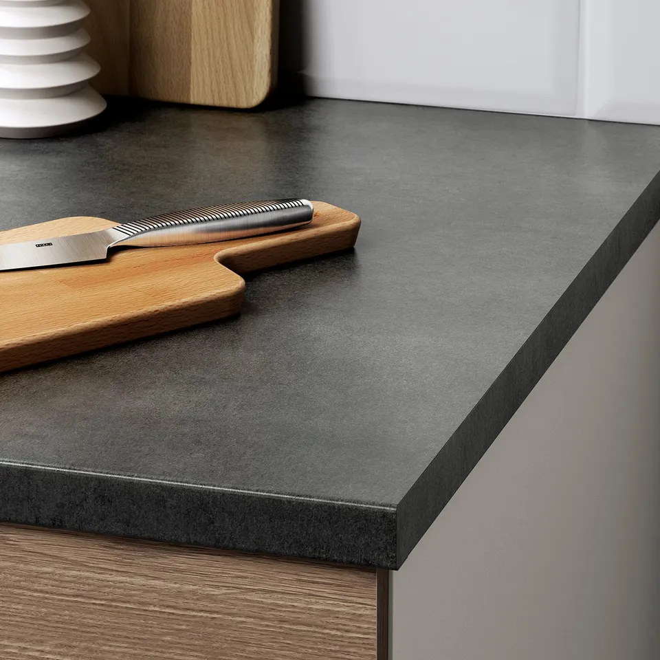 Black kitchen countertop with a knife and cutting board. Efficient for slicing and food prep.