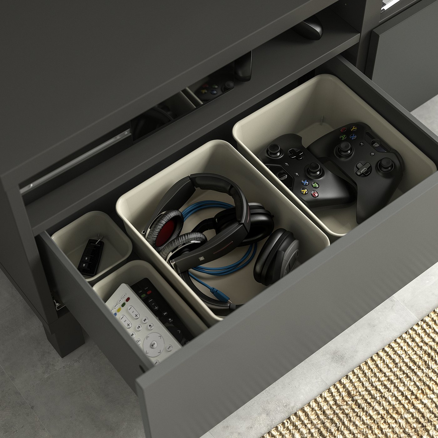 Open BESTÅ tv bench drawer in black holding gaming controllers, headphones, and remotes, organised in compartments.