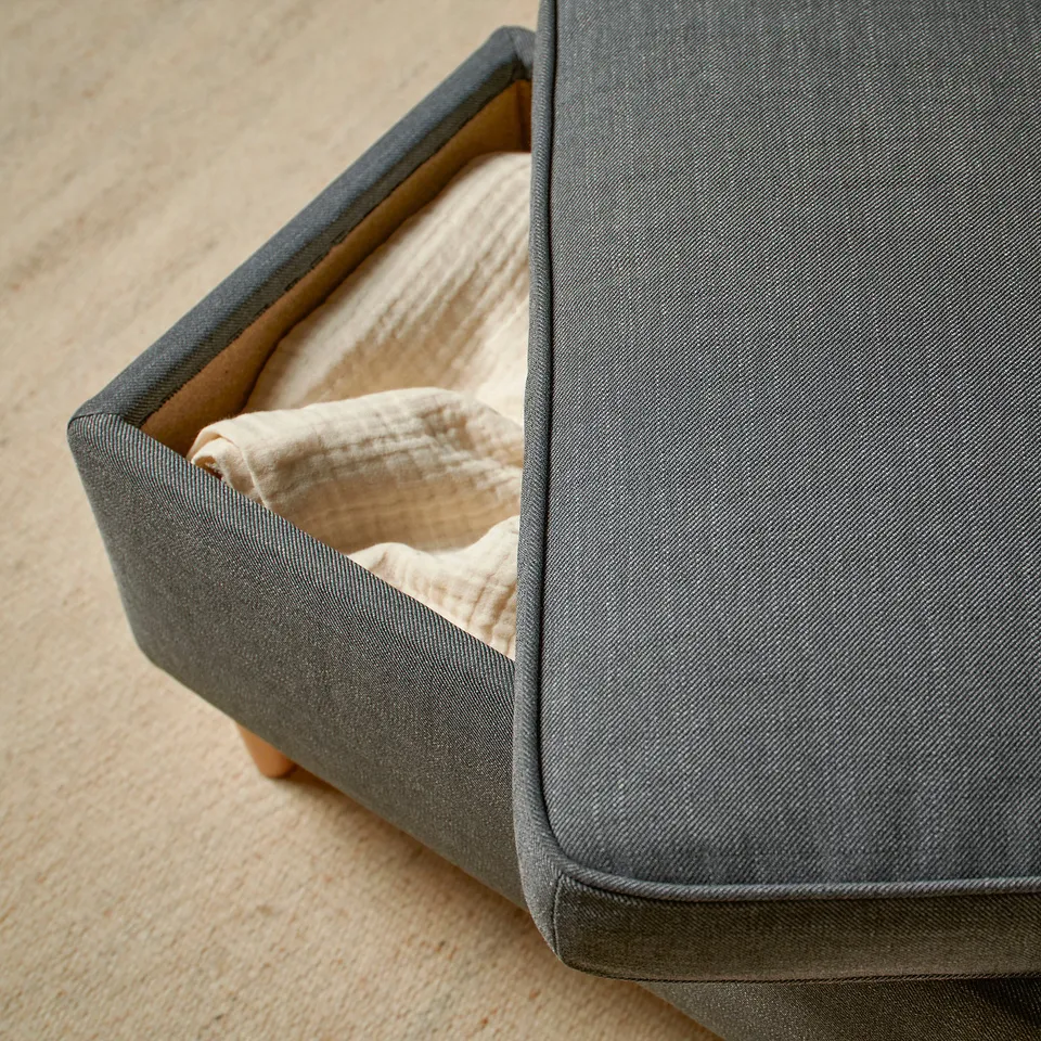 Grey fabric wing chair with chequered pattern and beige cushion, providing comfort and neck support.