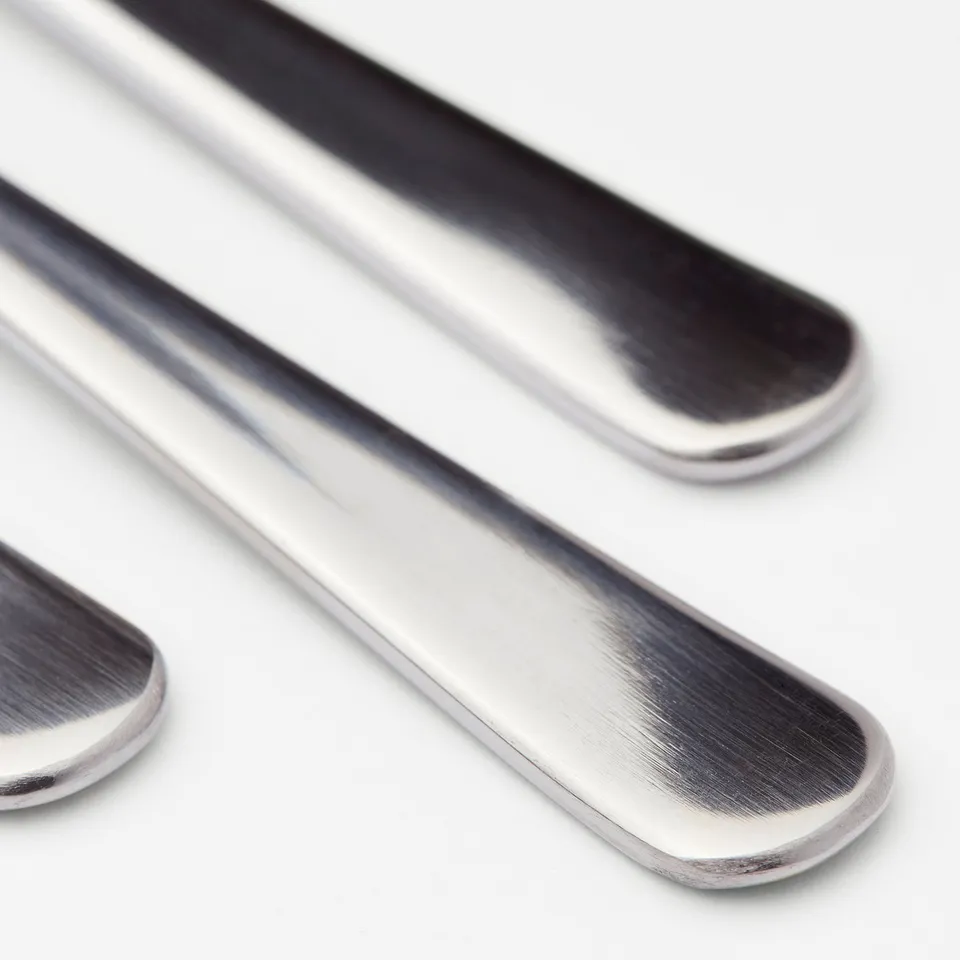 Close-up of sleek, polished stainless steel cutlery; reflects light and shows fine craftsmanship.