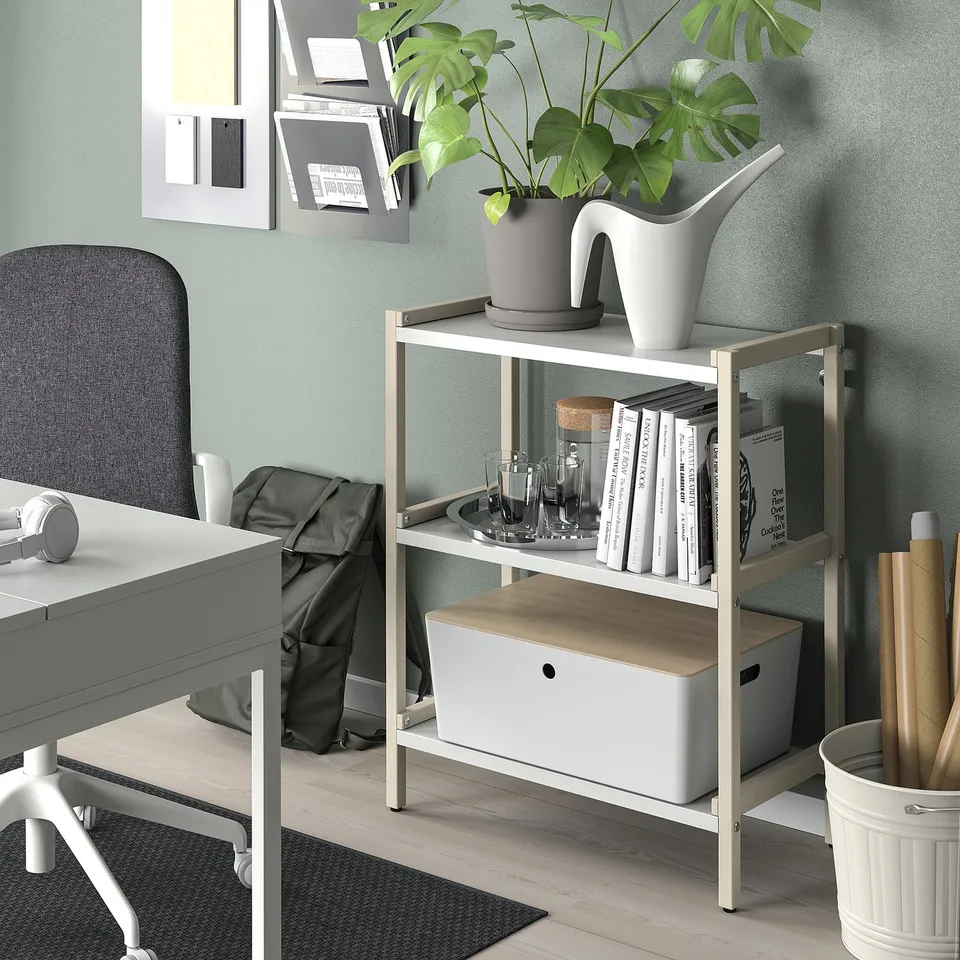 Modern home office with KUGGIS box, desk, chair, plant, books, and bulletin board.
