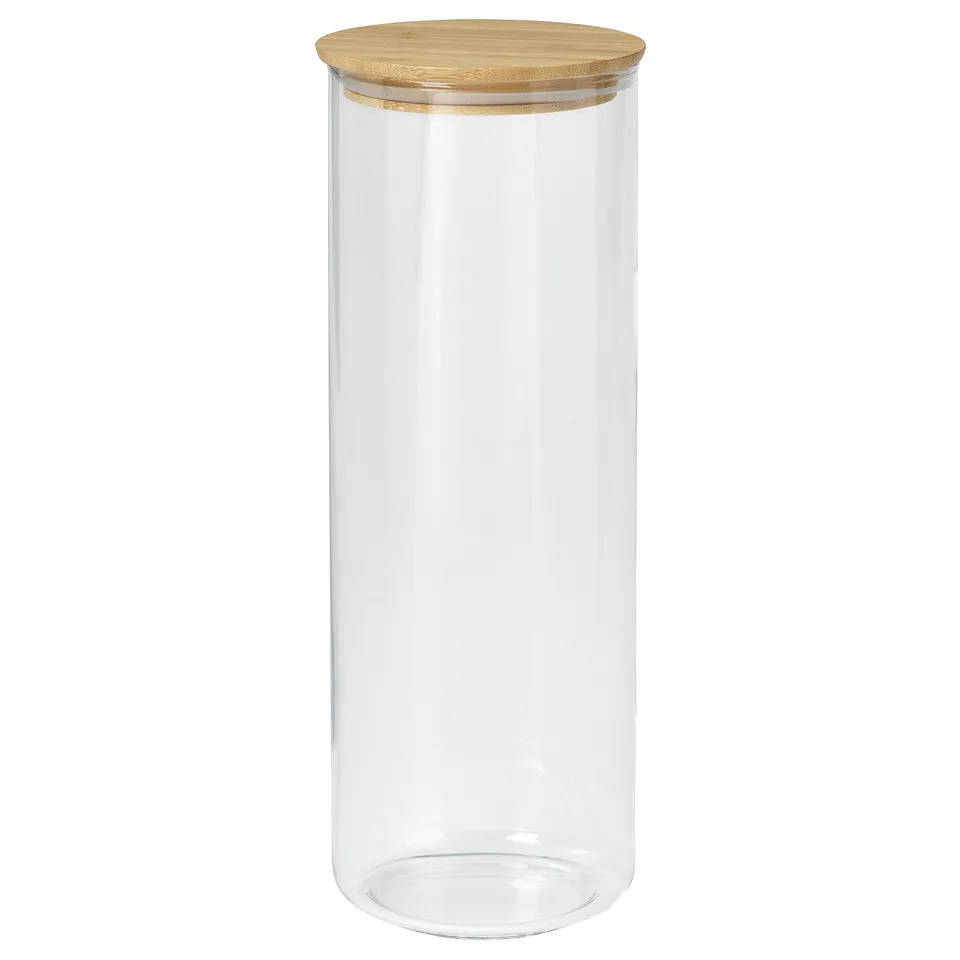 A clear glass jar named EKLATANT with a wooden lid. It is cylindrical, suitable for storing food, and has a simple, elegant design.