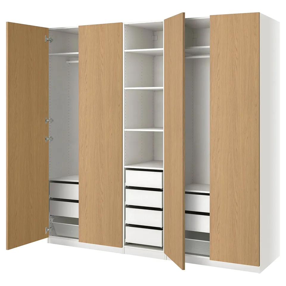 A light wooden PAX wardrobe with multiple shelves and drawers, offering versatile storage.