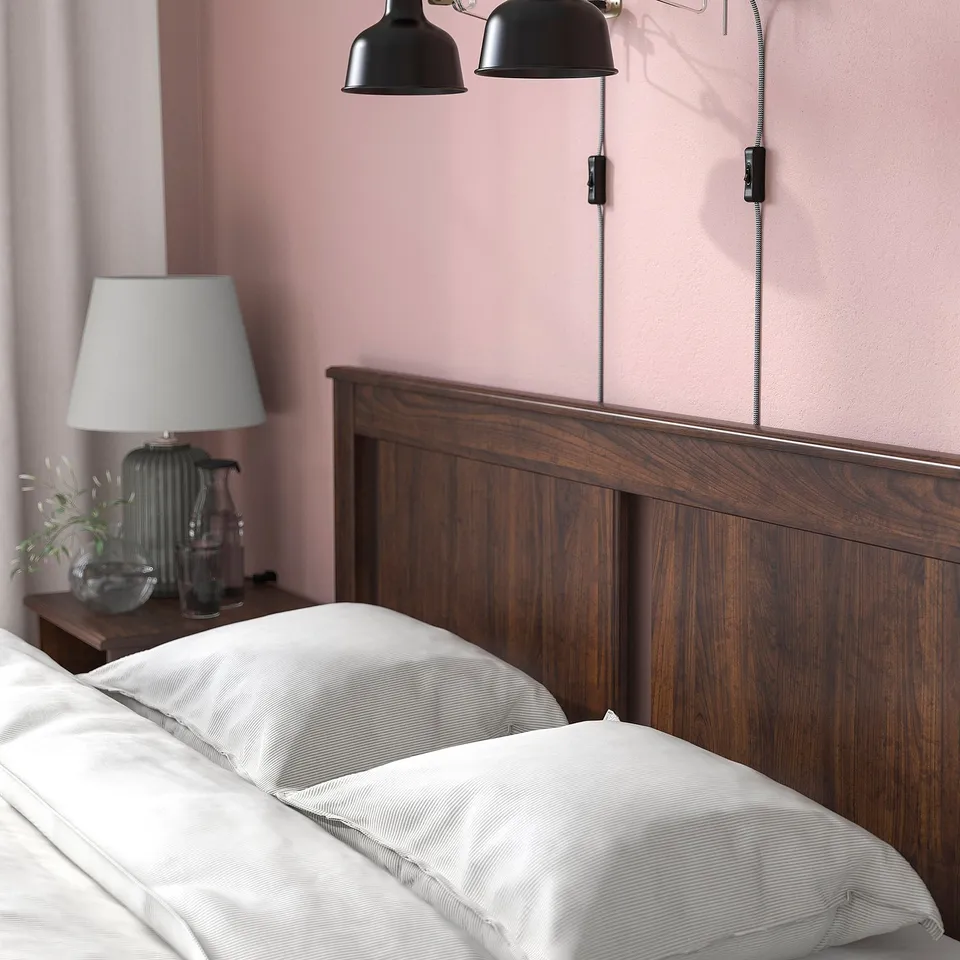 Wooden bed with white bedding, wall lights, adjustable sides.