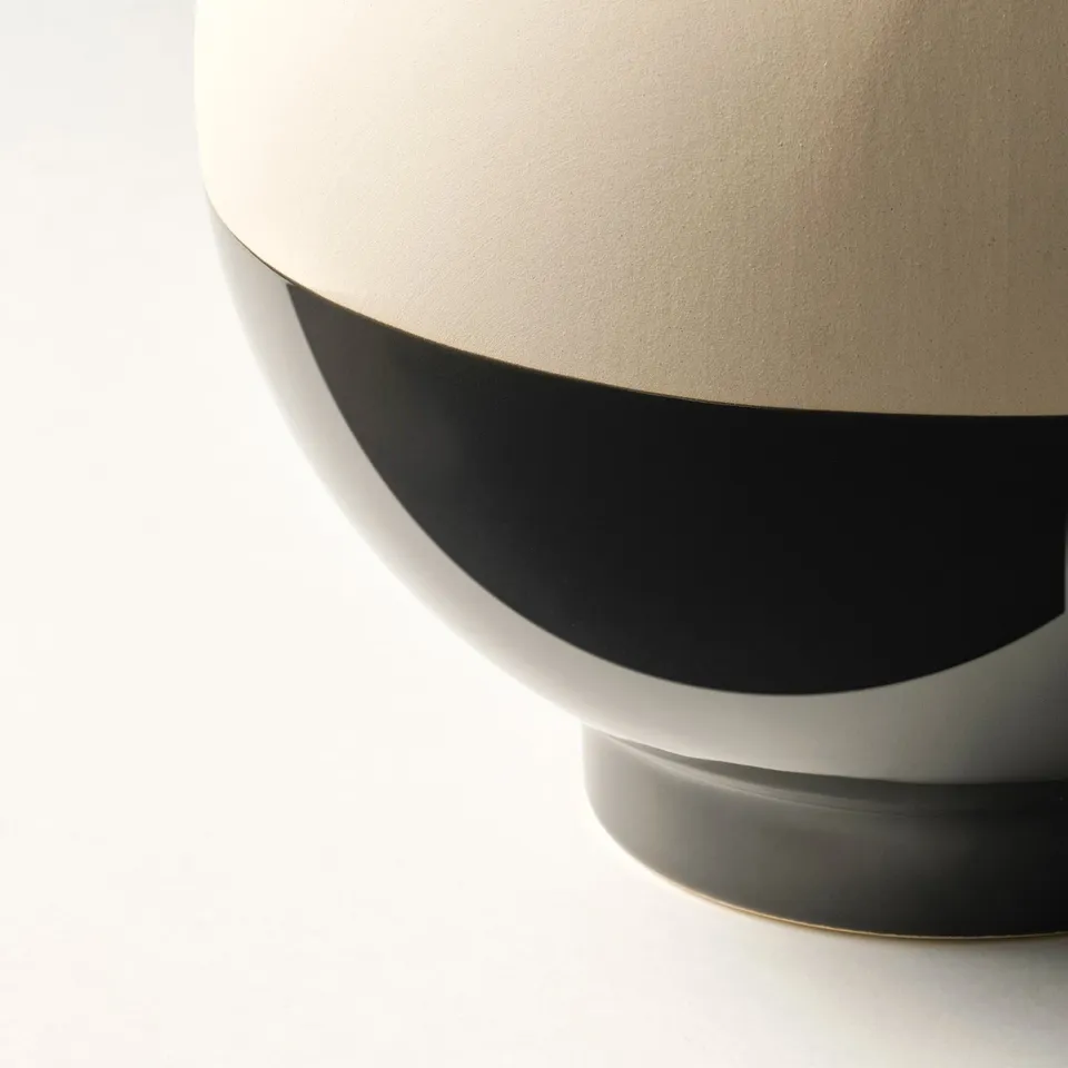 Modern vase with sleek contrast: beige matte top, glossy black bottom. Elegant design for contemporary spaces.