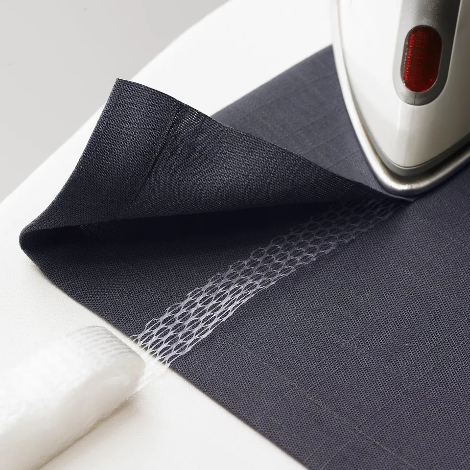Person using iron for no-sew fabric hemming.