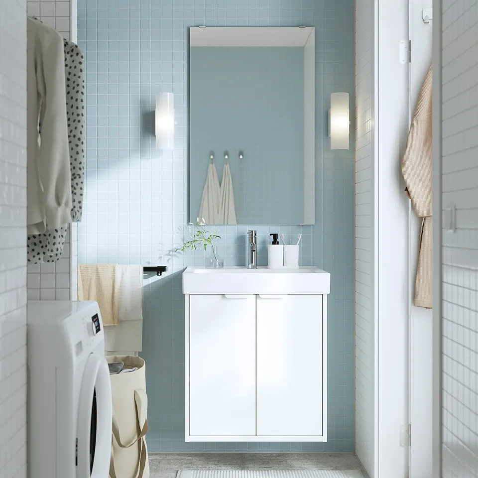 A blue-tiled bathroom with a white HAVBÄCK vanity, mirror, and towels.