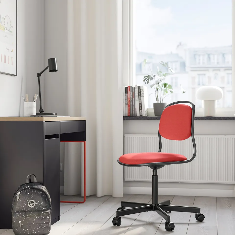 Red ÖRFJÄLL office chair in cosy room next to desk, lamp, backpack.