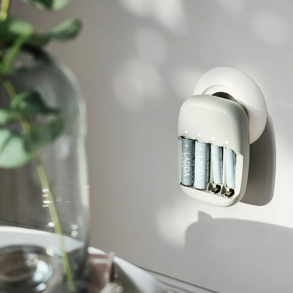 Wall-mounted STENKOL charger with four rechargeable batteries, made from recycled plastic.