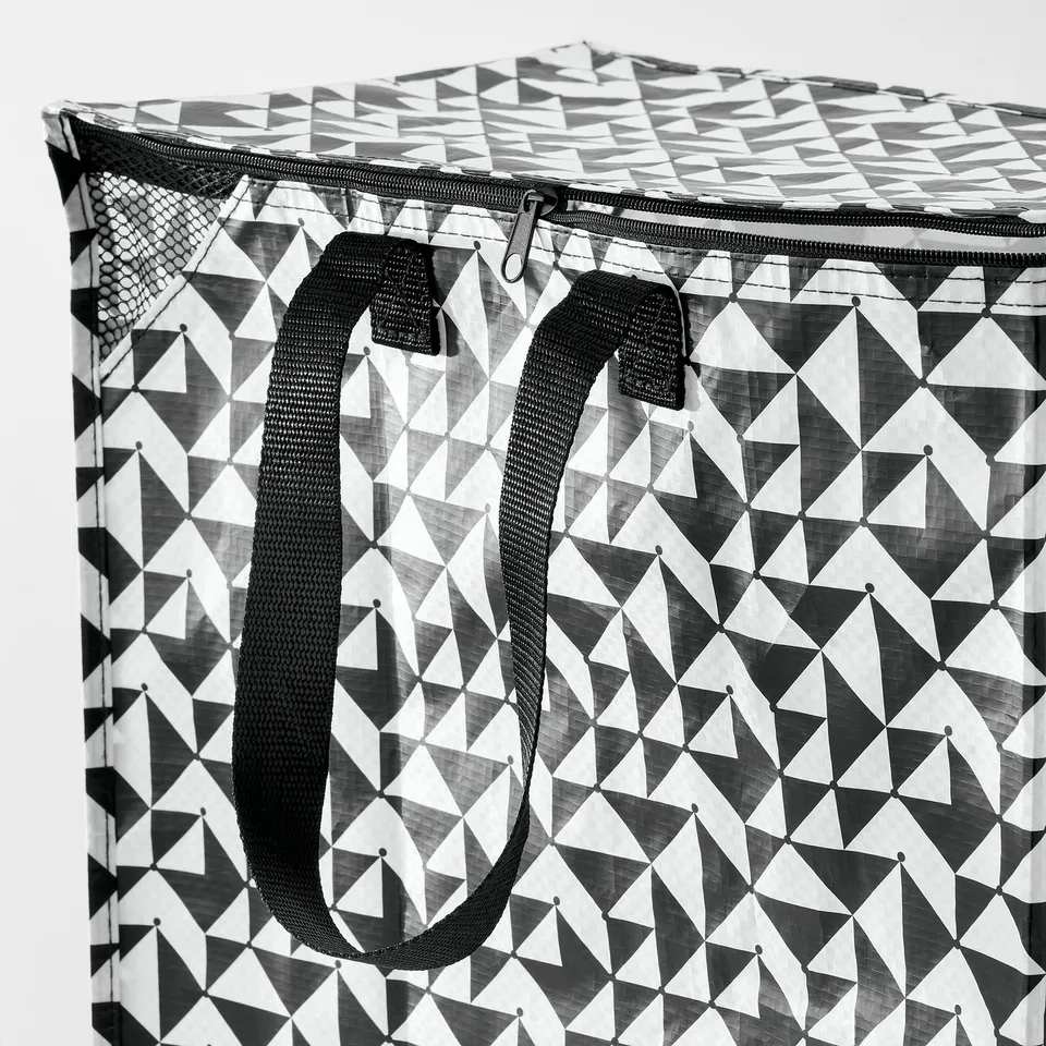 Geometric-patterned shopping bag with sturdy black handles and zip, showcasing high-quality craftsmanship.
