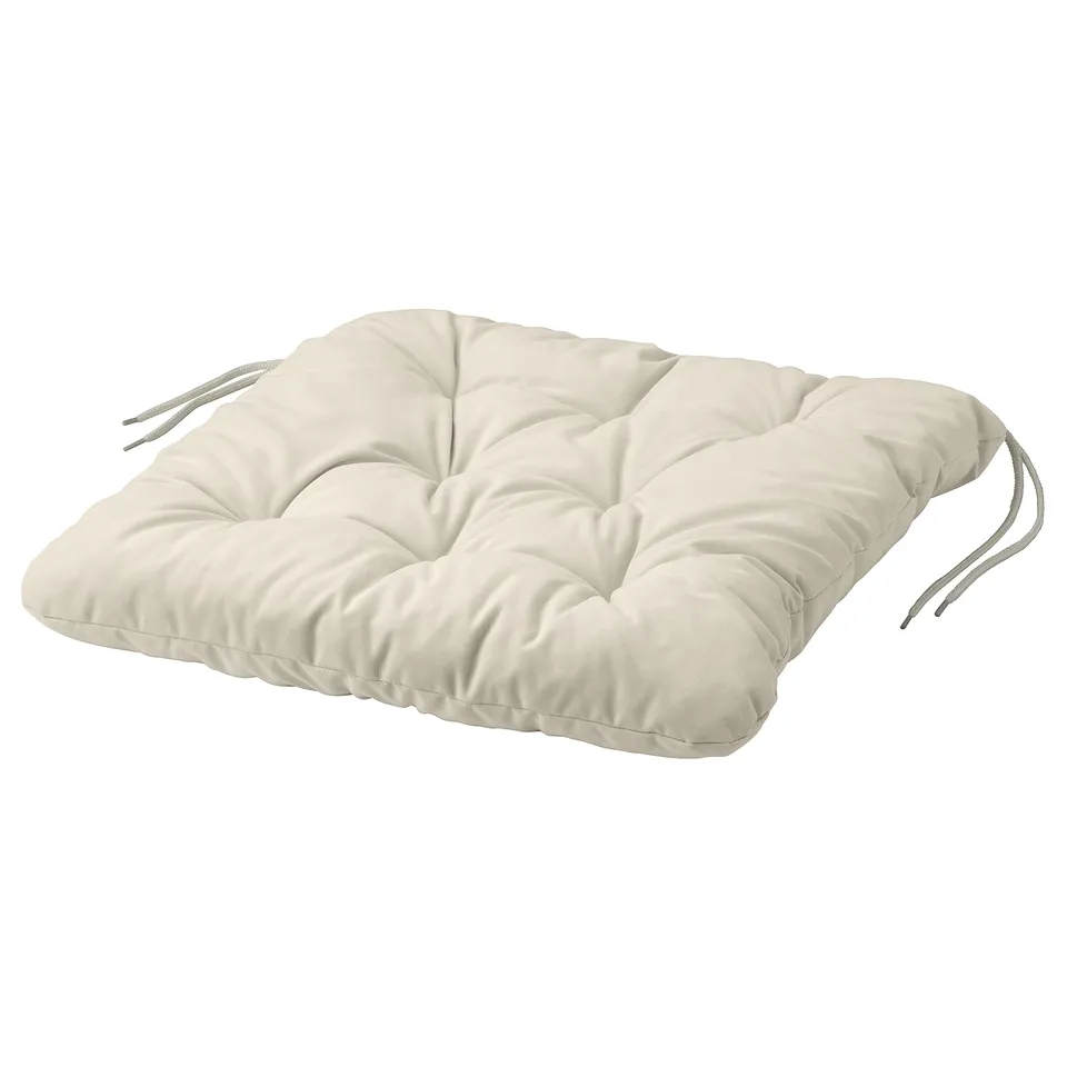 A KUDDARNA cream-colored, square-shaped outdoor cushion with tied corners, made from recycled polyester fabric and filling.