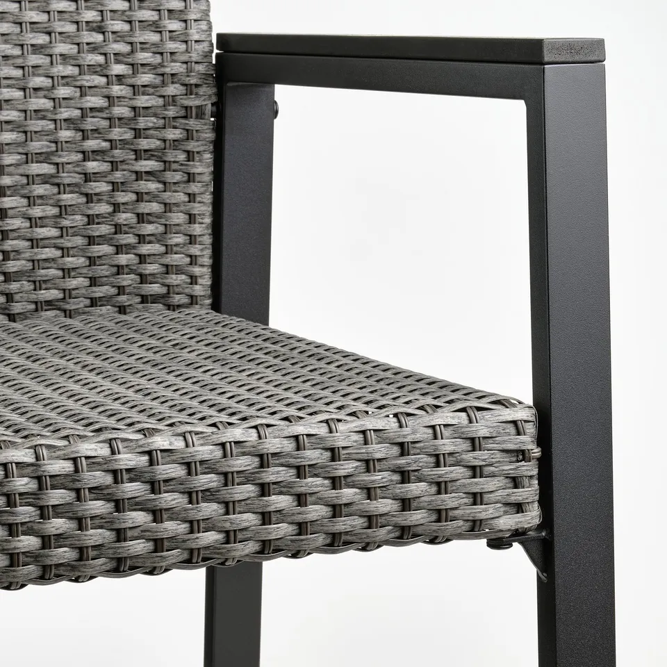 Black wicker outdoor chair with dark metal frame, showing close up of intricate weave and sturdy construction.