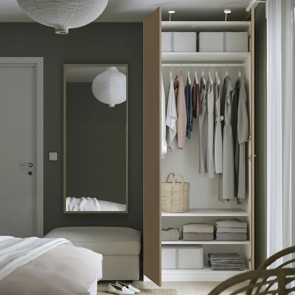 Modern PAX wardrobe with open door, clothes, and storage boxes.