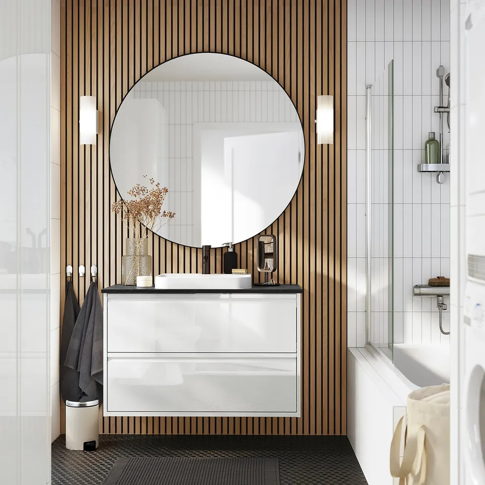 Modern bathroom with ÄNGSJÖN wash-stand, marble basin, full drawers, mirror, and wall sconces.