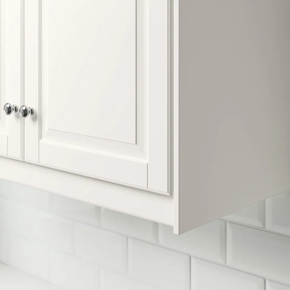 White kitchen cabinet with chrome handle and decorative underside.