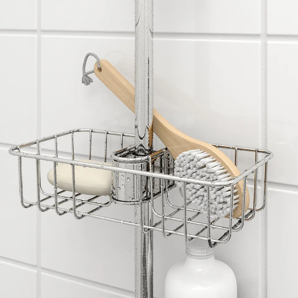 Metal shower caddy holds soap and brush on shower rail.