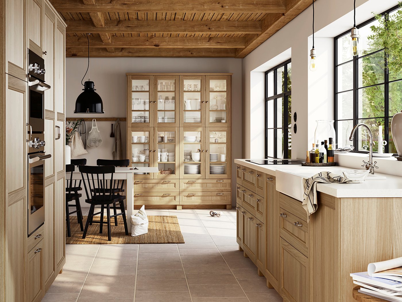 Modern kitchen with VEDHAMN light oak cabinets, black chairs, glass-fronted storage, and natural decor.