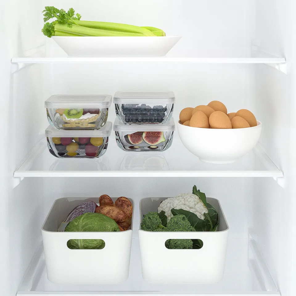 Fridge with stackable glass food containers, keeping fruits and veggies fresh and organised.