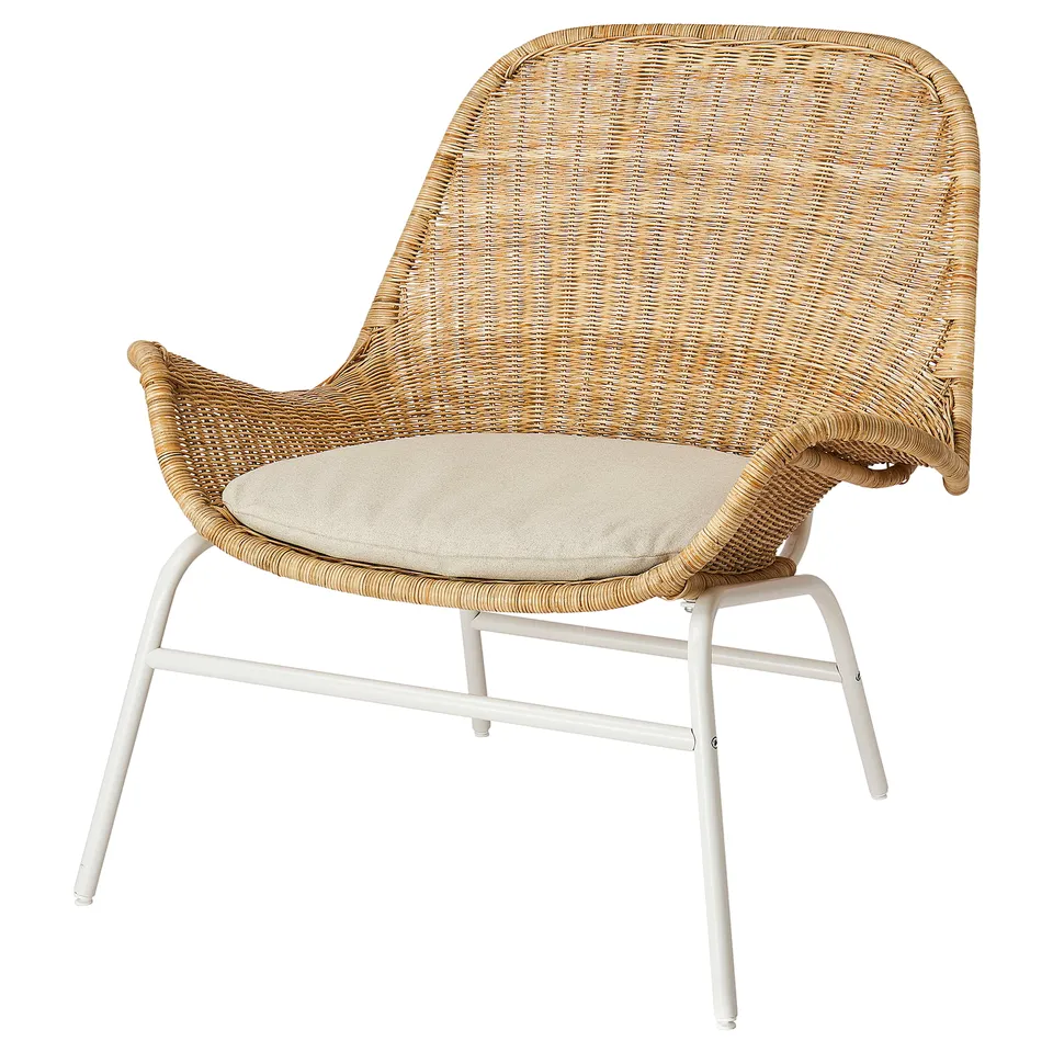 A beige FRYKSÅS wicker armchair with a cushioned seat, featuring a curved back and armrests, supported by white metal legs.
