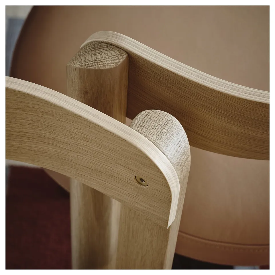 Chair detail: sleek oak frame, striped grain, smooth leather seat, crafted for comfort & durability.