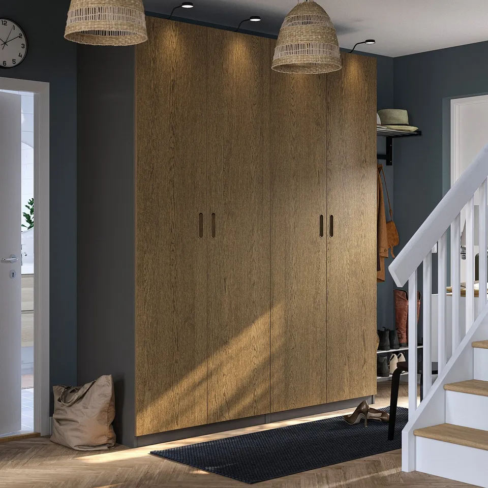 Modern entryway with oak PAX wardrobe, pendant lamps, staircase, coat stand, jute mat, and clock.