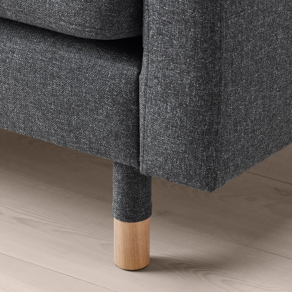 Modern sofa with dark grey fabric and wooden legs, showing high-quality design and comfort.