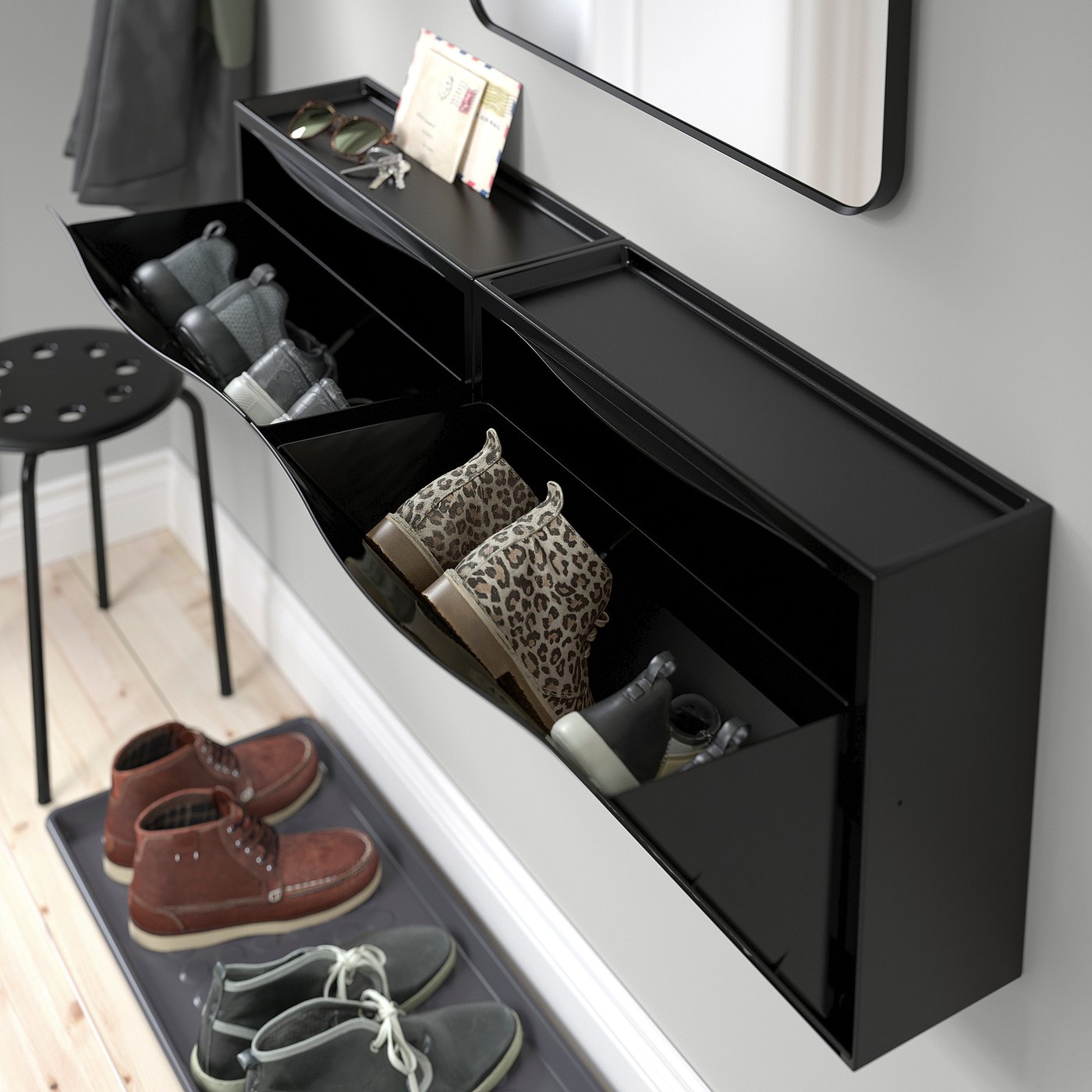 Black TRONES shoe cabinet, holding shoes in compartments, with a top surface for small items like keys and phones.