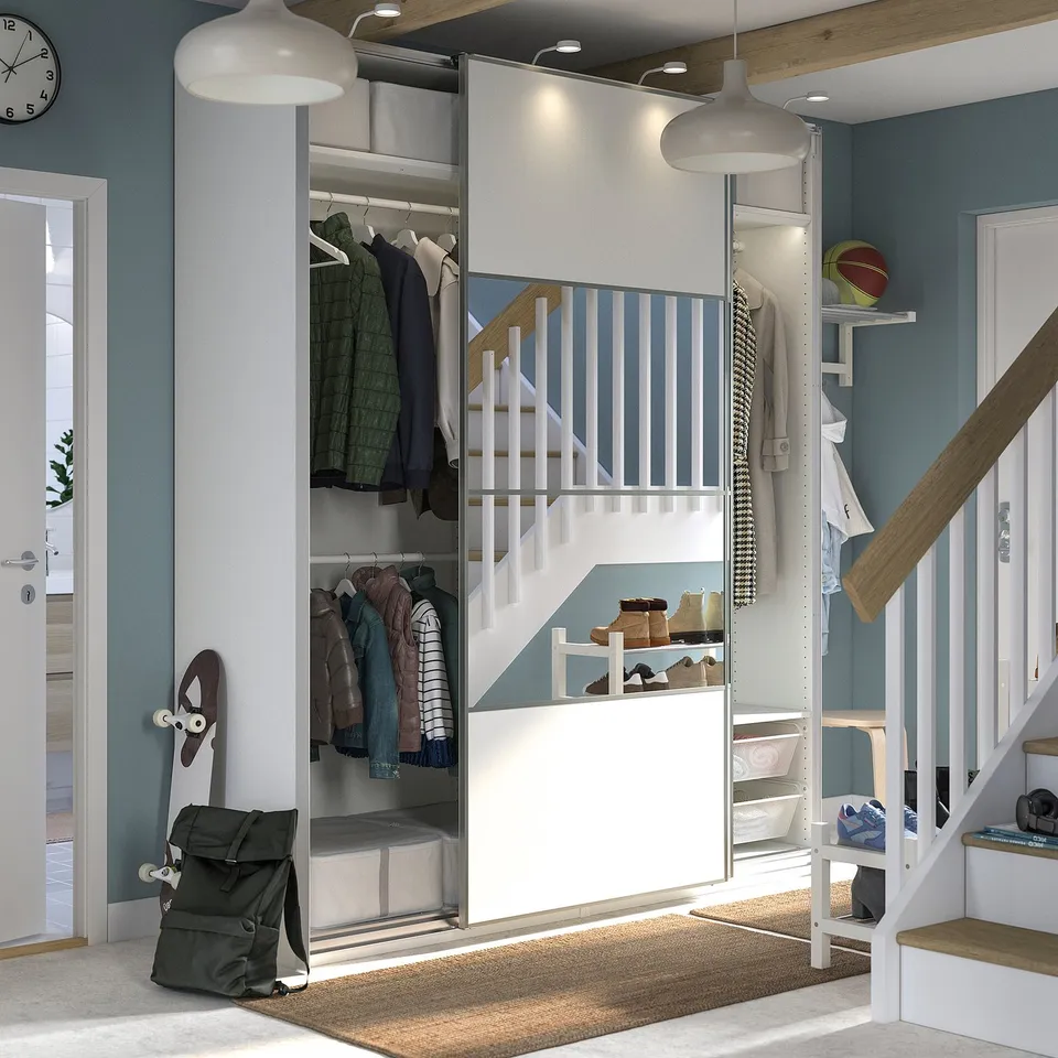 Modern closet with sliding doors, hanging clothes, shelves, and lighting.