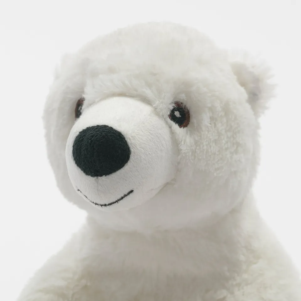 A close-up of a soft, plush white teddy bear with dark eyes and nose, showcasing its high-quality, huggable fabric.