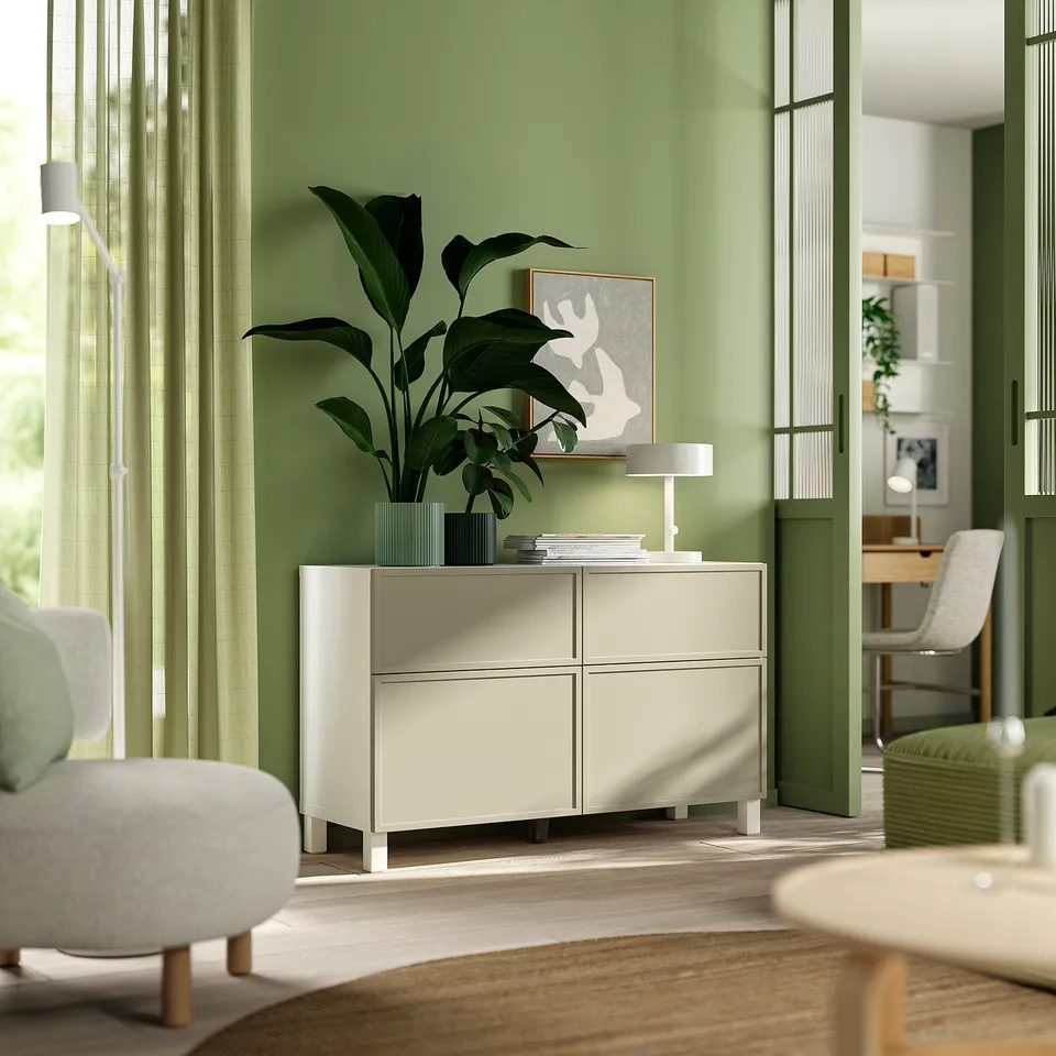 White BESTÅ storage unit with plant, art, lamp, between window and dining.