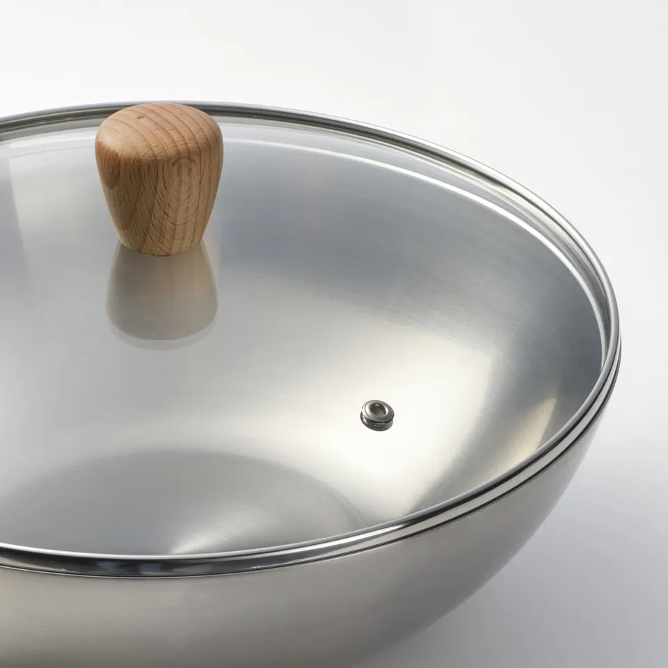 Stainless steel wok with glass lid.