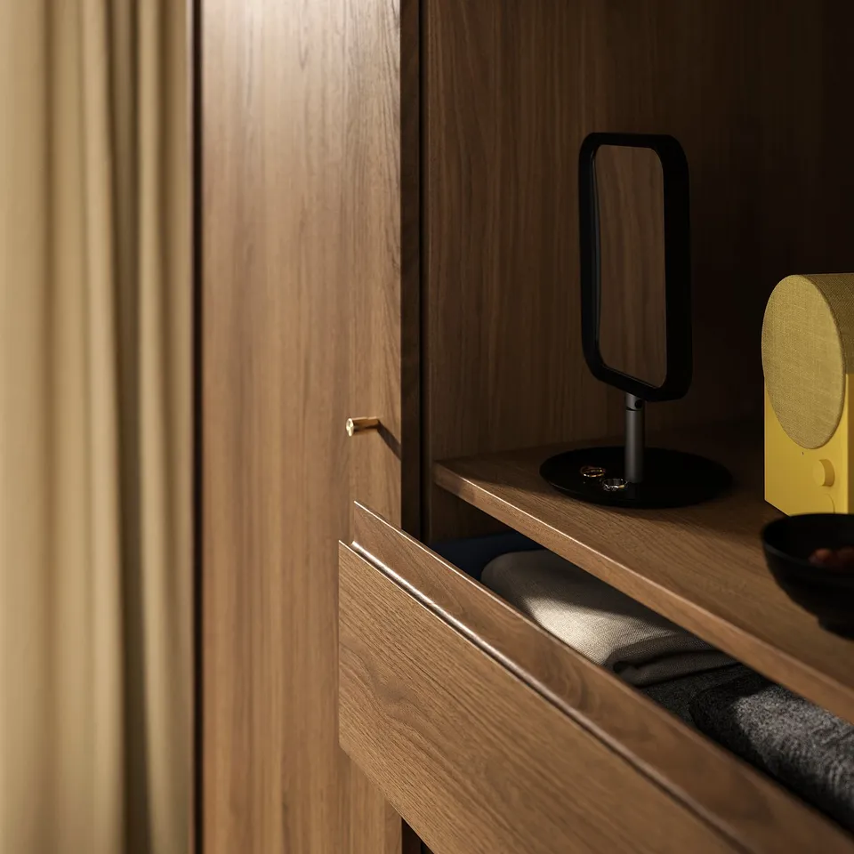 Mid-century style wooden wardrobe with sliding doors, containing drawers and shelves. Dark brown colour, sleek design.