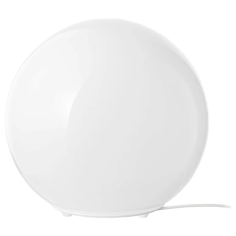 A FADO table lamp in white. Its spherical with a glass shade and a plastic base. Known for casting soft, mood lighting.